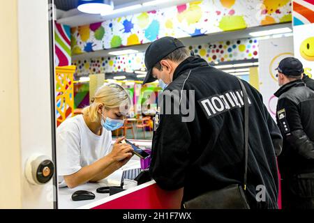 Zaporizhzhia, Ukraine.18 octobre 2021.ZAPORIZHHIA, UKRAINE - le 18 OCTOBRE 2021 - un officier de la police nationale d'Ukraine vérifie un certificat de vaccination COVID-19 d'un administrateur dans un complexe de loisirs lors d'un raid conjoint autour des centres commerciaux avec les représentants du Service national de l'alimentation et de la consommation, Zaporizhzhia, sud-est de l'Ukraine crédit:UKRINFORM/Alamy Live News Banque D'Images