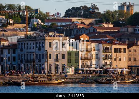 Porto, PORTUGAL - MAI 2018: Vue sur Vila Nova de Gaia, bateaux traditionnels et Duero River pendant un beau coucher de soleil au début du printemps Banque D'Images