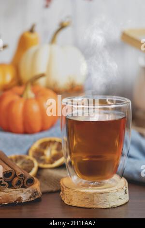 Thé avec décor d'automne, citrouilles, tranches d'orange sèches et cannelle sur table et fond blanc.Concept de Thanksgiving , automne, thé, tisane . Banque D'Images