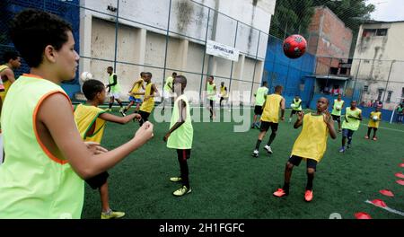 salvador, bahia / brésil - 24 juillet 2015: Des enfants sont vus pendant une formation dans une école de football sur un terrain de sport dans le quartier Candial dans le ci Banque D'Images