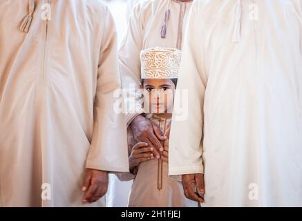 Nizwa, Oman, 2 décembre 2016 : portrait d'un garçon local en vêtements traditionnels au marché de la chèvre du vendredi à Nizwa, Oman Banque D'Images