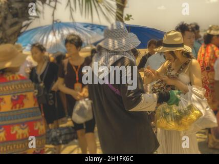 PATTAYA, THAÏLANDE - AVRIL 20,2018 : la plage de nombreux touristes en provenance de Chine vous détendre et nager et y louer des bateaux pour des excursions.Certains thaïs vendent des souvenirs,foo Banque D'Images