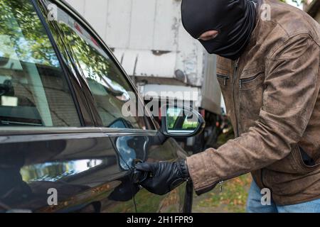 un voleur de voiture tente d'ouvrir une porte de voiture Banque D'Images