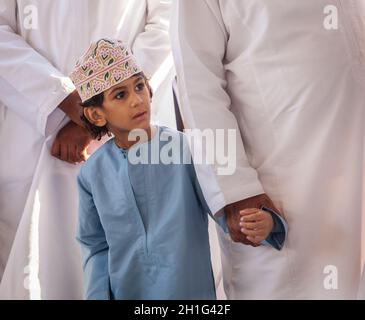 Nizwa, Oman, 2 décembre 2016 : portrait d'un garçon local en vêtements traditionnels au marché de la chèvre du vendredi à Nizwa, Oman Banque D'Images