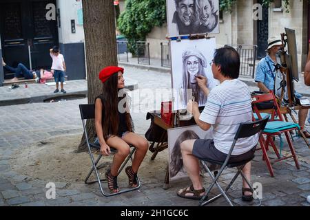 Paris, France - juillet 2019 : jolie petite fille touristique vêtue d'un béret rouge et représentée par un peintre de Montmartre, à la place du Tertre, dans quelques rues Banque D'Images