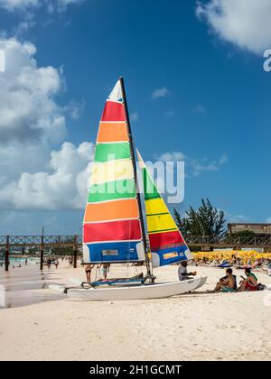 Bridgetown, Barbade - le 18 décembre 2016 : plage de Brownes à côte de l'océan avec les gens et coloré sur un yacht à voile journée ensoleillée à Bridgetown, Barbade. Banque D'Images