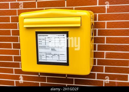 Oberkleen, Allemagne - 2020-05-16 , boîte aux lettres jaune du Bundespost allemand suspendue sur une façade de maison en allemagne. Banque D'Images