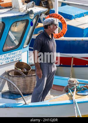 Héraklion, Grèce - 12 novembre 2019 : un bâtard non identifié, debout dans un bateau de pêche en bois, dans le port d'Héraklion, sur l'île de Crète, en Grèce. Banque D'Images