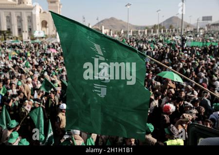 Sanaa, Yémen.18 octobre 2021.Un homme porte un drapeau en lisant « à votre commande » lors d'une célébration par les rebelles houthistes pour marquer l'anniversaire de la naissance du prophète Mahomet de l'Islam (Mawlid al-Nabi) à Sanaa.Credit: Hani al-ANSI/dpa/Alay Live News Banque D'Images