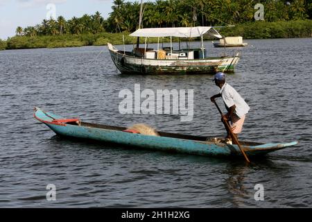 Camamu, bahia / brésil - 10 janvier 2012: Le pêcheur est vu pagayer son canoë à Baia de Camamu, dans la municipalité de Camamu, dans le sud de Bahia. Banque D'Images