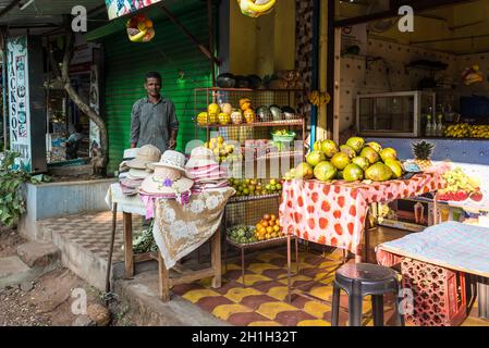 Candolim, North Goa, Inde - 23 novembre 2019 : un vendeur local vend des fruits frais et des chapeaux à Candolim, North Goa, Inde. Banque D'Images