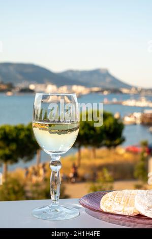 Été sur la Côte d'Azur, boire du vin blanc froid des Côtes de Provence sur une terrasse extérieure avec vue sur le port de Toulon, Var, France Banque D'Images