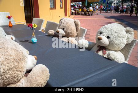 Un groupe d'ours Teddy assis à une table et prêt pour un déjeuner ou une réunion Banque D'Images