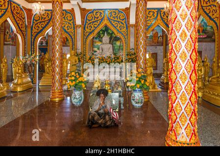 Phuket, Thaïlande - 29 novembre 2019 : une femme prie dans l'une des salles du Temple Wat Chalong ou du Temple Wat Chaiyathararam dans la province de Phuket, Tha Banque D'Images