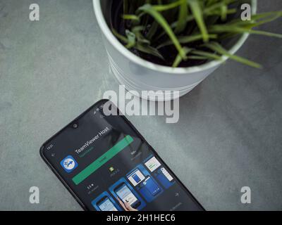 LOD, Israël - 8 juillet 2020 : espace de travail moderne et minimaliste avec smartphone mobile noir avec TeamViewer Host application play store page sur le backgro de marbre Banque D'Images