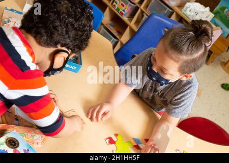 Éducation préscolaire 4-5 ans deux garçons travaillant sur le puzzle ensemble Banque D'Images