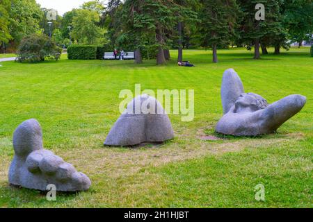 TALLIN, ESTONIE - 15 JUILLET 2019 : les gens se reposent dans un parc municipal avec une sculpture moderne au premier plan Banque D'Images