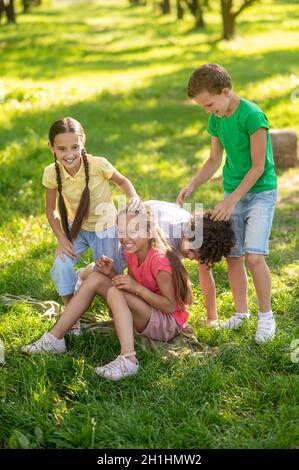 Enfants heureux jouant sur la pelouse dans le parc Banque D'Images