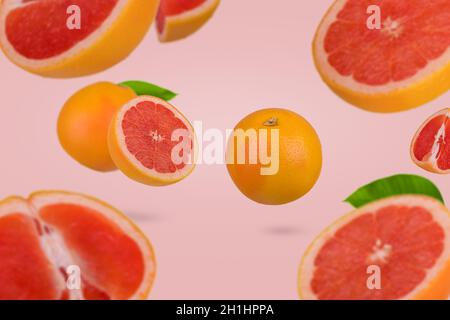 Idée créative avec pamplemousse frais tranché sur fond rose pastel.Concept de fruit minimal.Vitamines, concept de régime sain.Tranché et grapefru entier Banque D'Images