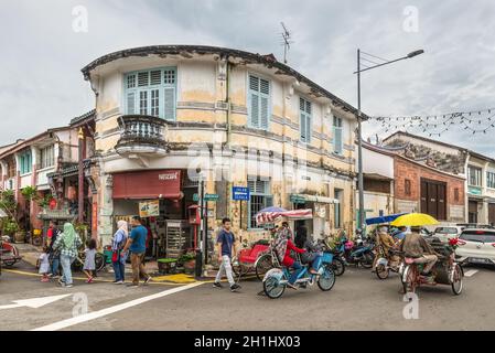 George Town, Penang, Malaisie - 1 décembre 2019: La vie de rue avec le rickshaw local classique à George Town, Penang, Malaisie par temps nuageux. Banque D'Images