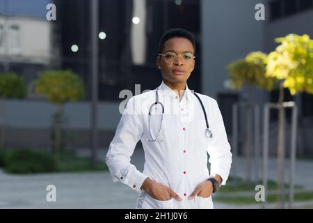 Portrait d'une femme médecin pédiatre sérieuse près de la clinique dans une robe médicale Banque D'Images