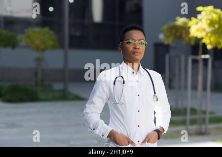 Portrait d'une femme médecin pédiatre sérieuse près de la clinique dans une robe médicale Banque D'Images