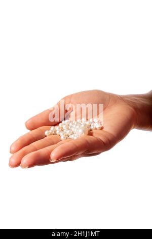 Main de femme avec une poignée de perles blanches pour collier.Isolé sur fond blanc. Banque D'Images