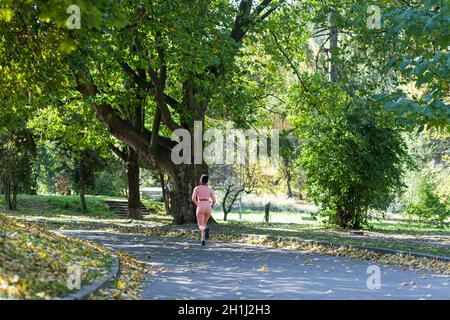 Jeune femme afro-américaine sur un jogging matinal dans le parc d'automne Banque D'Images
