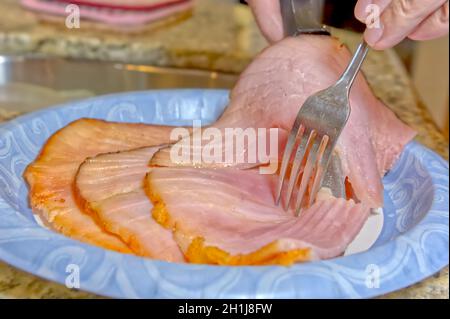 Tranches de jambon de Noël cuit servies sur une assiette en papier. Banque D'Images