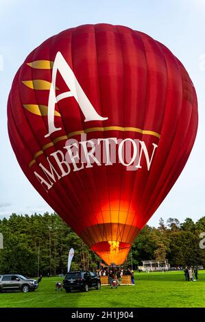 Vilnius, Lituanie - 14 septembre 2021 : la flamme remplit un ballon d'air chaud rouge vibrant rempli de passagers avec du gaz d'air chaud le préparant au décollage à Banque D'Images