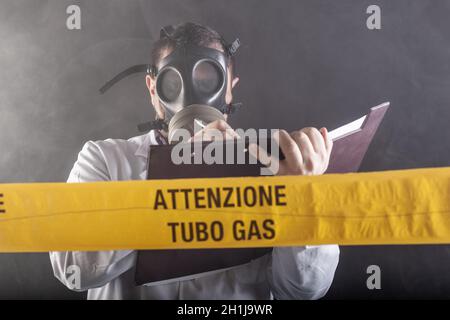 Un ingénieur médical portant un masque antigaz expérimenté dans la crise des fuites de gaz dirigeant l'urgence pendant le chaos.Sur la bande jaune, le n Banque D'Images