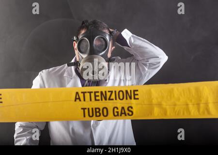 Un ingénieur médical portant un masque antigaz expérimenté dans la crise des fuites de gaz dirigeant l'urgence pendant le chaos.Sur la bande jaune, le n Banque D'Images