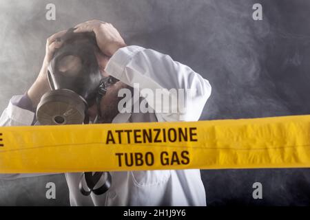 Un ingénieur médical portant un masque antigaz expérimenté dans la crise des fuites de gaz dirigeant l'urgence pendant le chaos.Sur la bande jaune, le n Banque D'Images