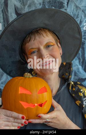 Gennevilliers, France - 10 16 2021: Une sorcière préparant une citrouille pour Halloween Banque D'Images