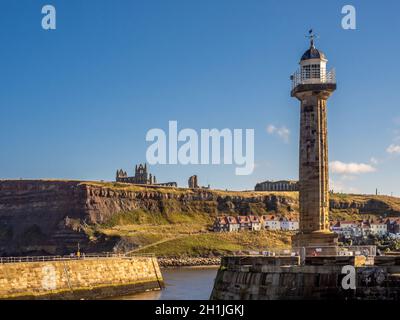 Phare ouest à l'entrée de Lower Harbour, avec l'abbaye de Whitby et l'église St Mary, falaise est au loin, Whitby, Royaume-Uni Banque D'Images