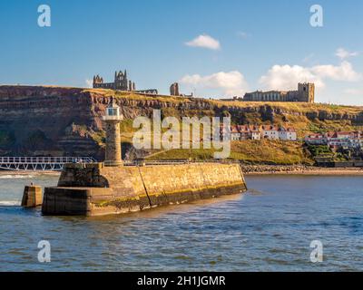 L'église Sainte-Marie et l'abbaye de Whitby sont en ruines au-dessus des cottages de la rue Henrietta, avec le phare est et le port en premier plan.Whitby. Banque D'Images