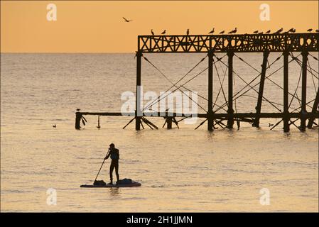 Pédalo silhoueté sur la jetée ouest abandonnée au coucher du soleil, Brighton, Angleterre.Construit en 1866 et fermé en 1975, le quai est toujours classé de catégorie I et un site bien connu. Banque D'Images