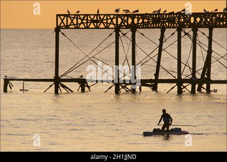 Pédalo silhoueté sur la jetée ouest abandonnée au coucher du soleil, Brighton, Angleterre.Construit en 1866 et fermé en 1975, le quai est toujours classé de catégorie I et un site bien connu. Banque D'Images