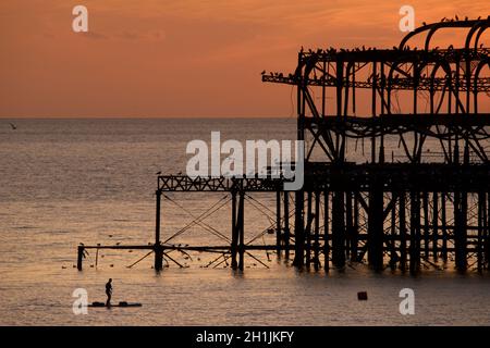 Pédalo silhoueté sur la jetée ouest abandonnée au coucher du soleil, Brighton, Angleterre.Construit en 1866 et fermé en 1975, le quai est toujours classé de catégorie I et un site bien connu. Banque D'Images