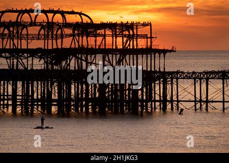 Pédalo silhoueté sur la jetée ouest abandonnée au coucher du soleil, Brighton, Angleterre.Construit en 1866 et fermé en 1975, le quai est toujours classé de catégorie I et un site bien connu. Banque D'Images