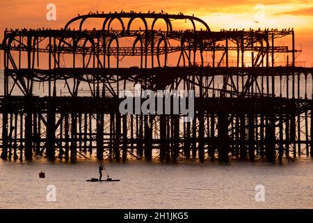 Pédalo silhoueté sur la jetée ouest abandonnée au coucher du soleil, Brighton, Angleterre.Construit en 1866 et fermé en 1975, le quai est toujours classé de catégorie I et un site bien connu. Banque D'Images