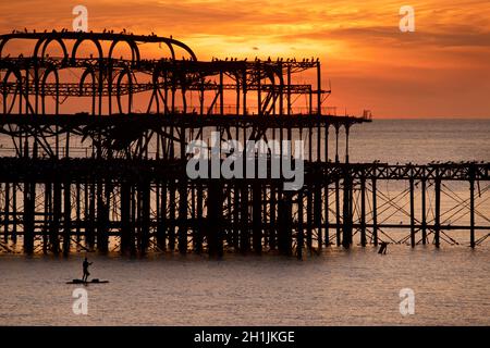 Pédalo silhoueté sur la jetée ouest abandonnée au coucher du soleil, Brighton, Angleterre.Construit en 1866 et fermé en 1975, le quai est toujours classé de catégorie I et un site bien connu. Banque D'Images