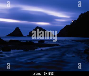 Phare de Heceta Head à Devils Elbow State Park Lane County point de vue pittoresque le long de la côte de l'Oregon coucher de soleil, rivière avec un format de roche silhouetté Banque D'Images