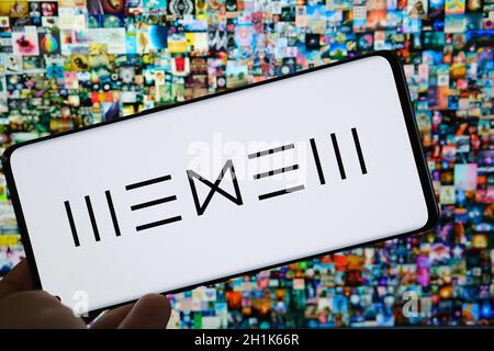 Le logo de la plate-forme Beeple WENEW de l'artiste numérique est visible sur son smartphone et son collage d'art numérique NFT « Everydays the First 5000 Days » sur fond flou. Banque D'Images