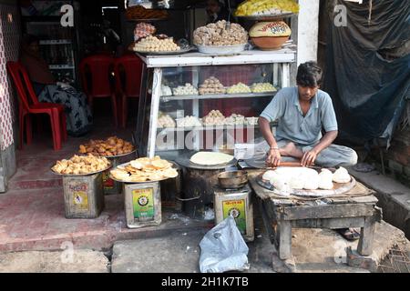 Le vendeur est en position lotus tandis que vend des marchandises à Sonakhali, Bengale-Occidental, Inde Banque D'Images