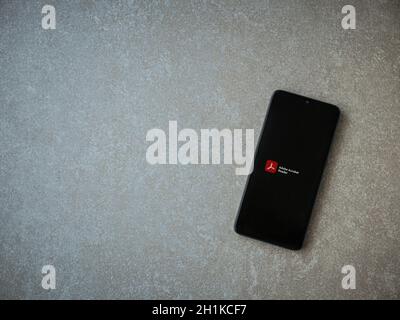 LOD, Israël - 8 juillet 2020 : écran de lancement de l'application Adobe Acrobat Reader avec logo sur l'écran d'un smartphone mobile noir sur fond de pierre céramique. Banque D'Images