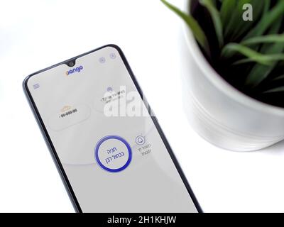 LOD, Israël - 8 juillet 2020 : espace de travail moderne minimaliste avec smartphone mobile noir avec écran de lancement de l'application Pango avec logo en texte hébreu sur W Banque D'Images
