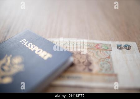 Photo d'un passeport flou des États-Unis d'Amérique avec un projet de loi de cinquante Kyats birmans partiellement à l'intérieur Banque D'Images