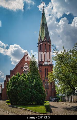 Belle église en brique rouge avec une tour d'horloge, une paroisse évangélique d'Augsbourg. Église de la Sainte Trinité à Szczecin, Pologne Banque D'Images