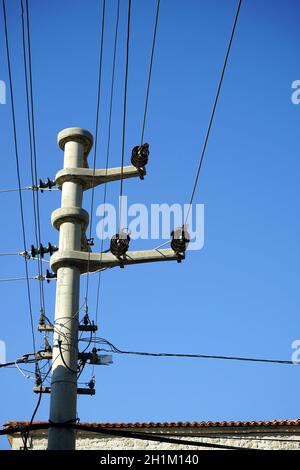 Gros plan d'un poteau électrique avec des fils avec un ciel bleu Banque D'Images